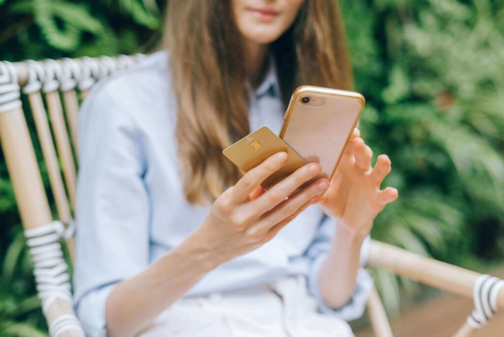 A woman looking at her credit score on a smartphone with a calm, relieved expression