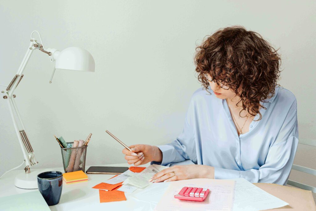 Woman sitting at a desk reviewing financial documents and a credit card application