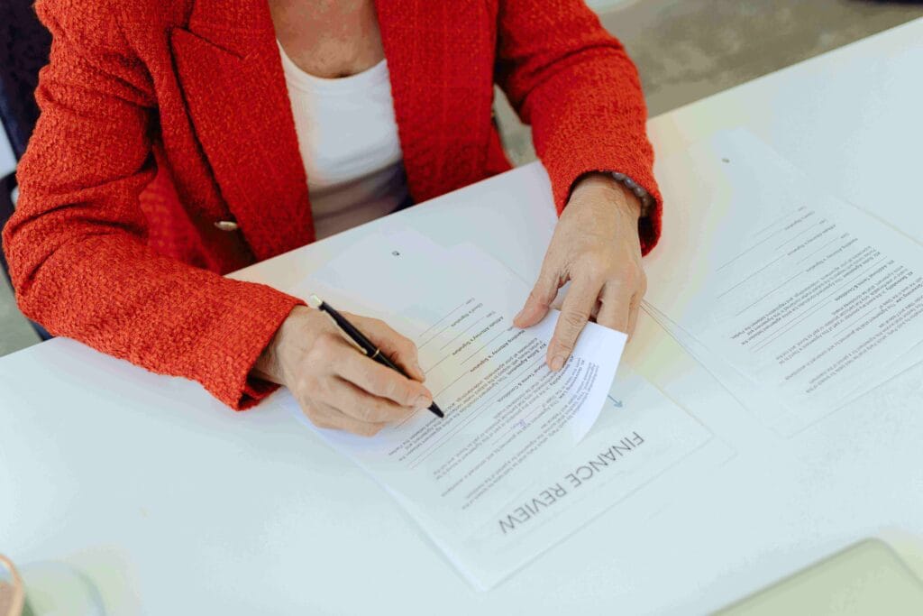 Woman reviewing credit report documents on a laptop, preparing to file a dispute with a credit bureau