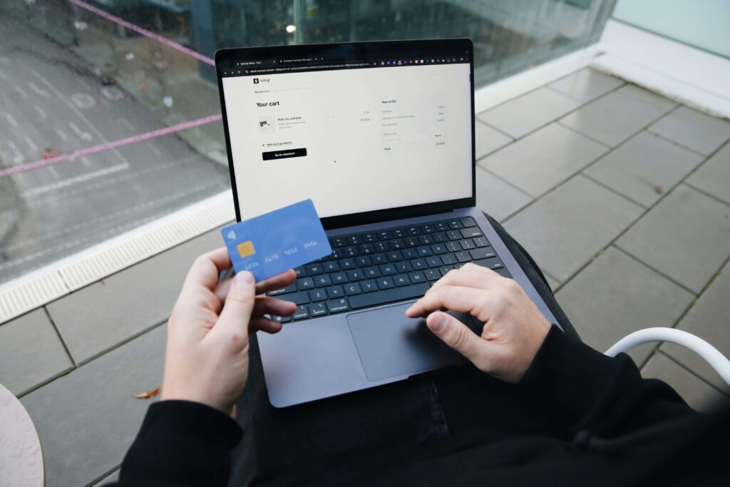 Man reviewing credit card application on laptop with credit score chart visible on screen