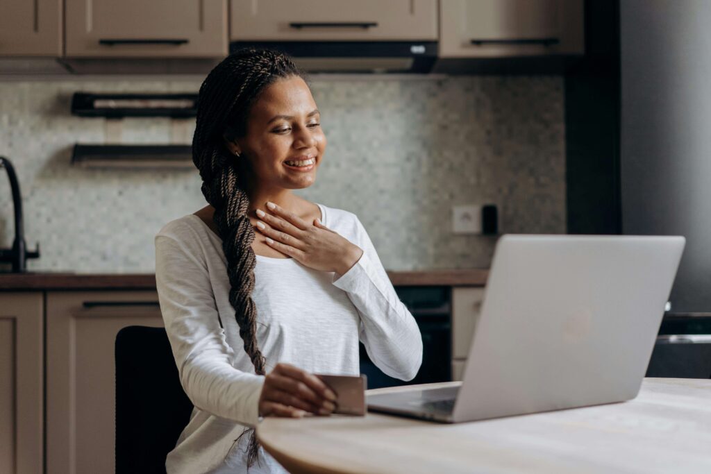  A woman reviewing her credit card statement and smiling after successfully requesting a credit limit increase online