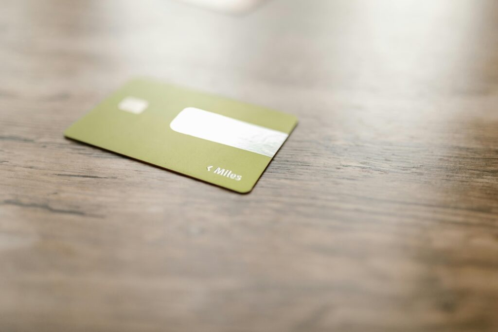 A secured credit card on a table next to a small plant and notebook, representing a fresh start with credit building