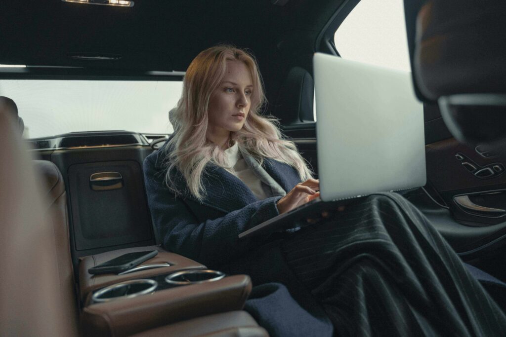 A woman reviewing her credit score on a laptop while researching auto loan options before buying a car in the USA