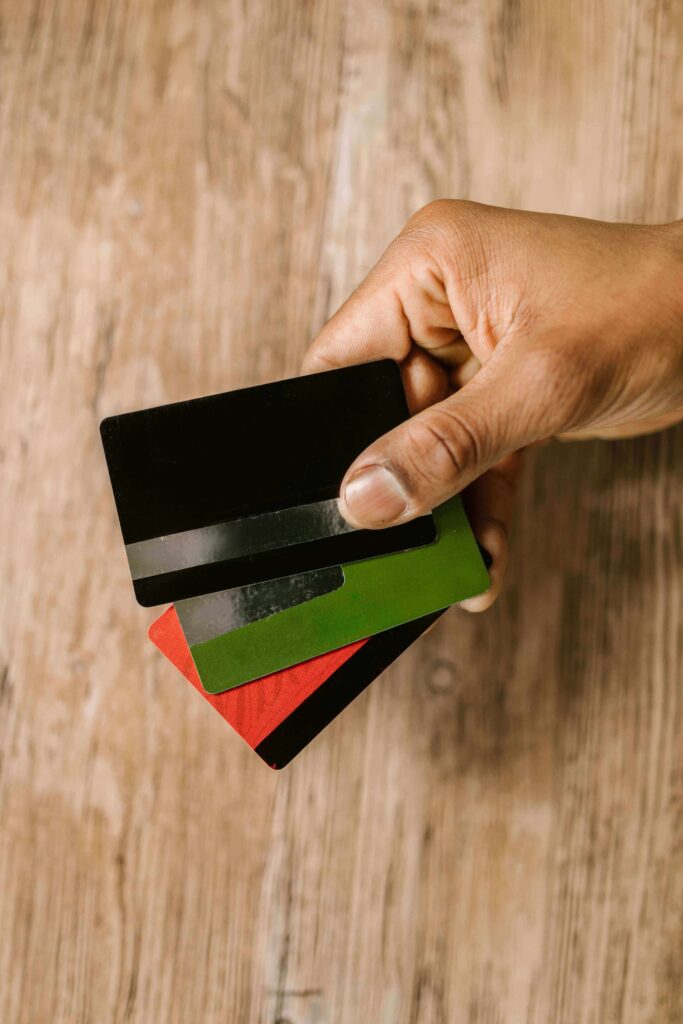A woman organizing multiple credit cards on a desk, deciding how many to keep for the best credit score