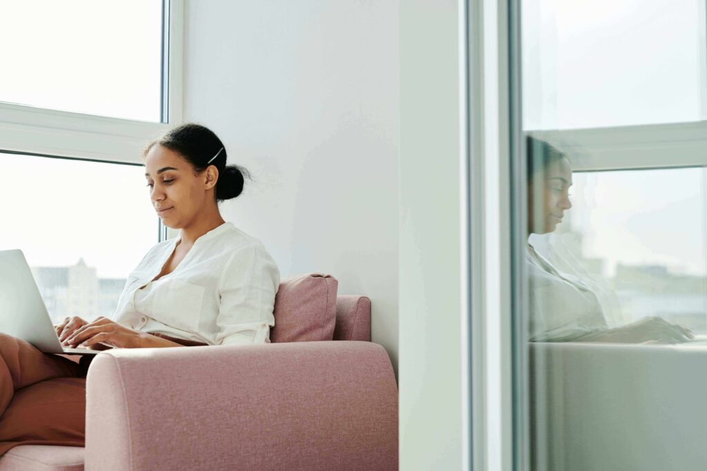 A woman reviewing her credit report on a laptop while browsing apartment listings online