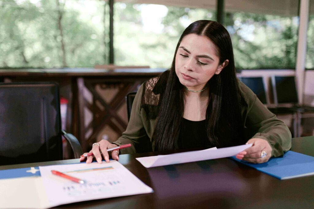 A person reviewing financial documents and a U.S. credit card, representing an immigrant building credit in America